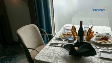 Mesa de restaurante con comida francesa y vino ventana mar de fondo alma cruceros crucerum