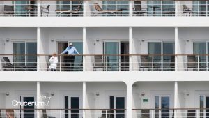 costa del barco vista de las habitaciones hombre de pie en el balcón mujer descansa en tumbona cruceros 2026